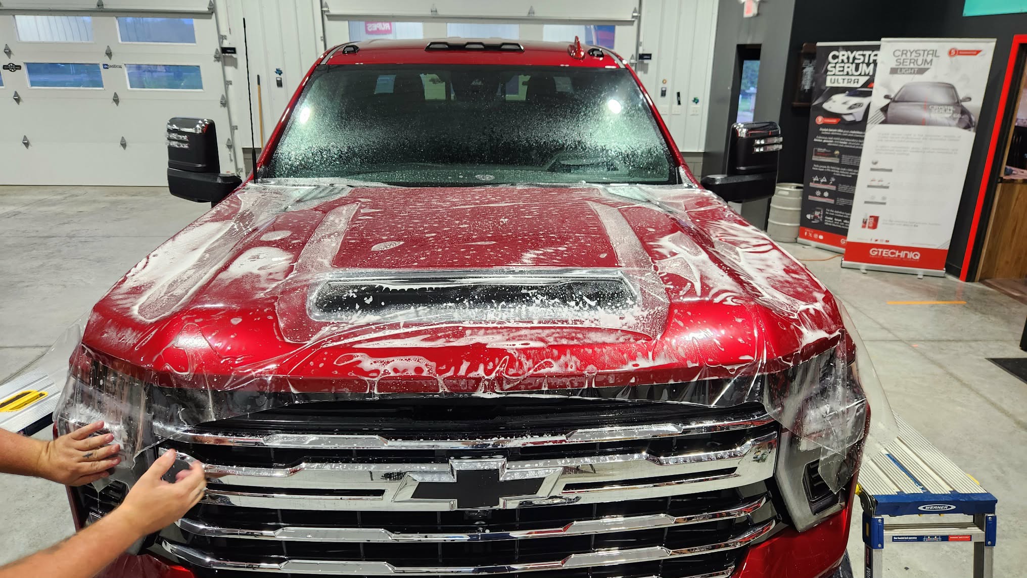 Red Chevrolet Silverado during PPF hood install